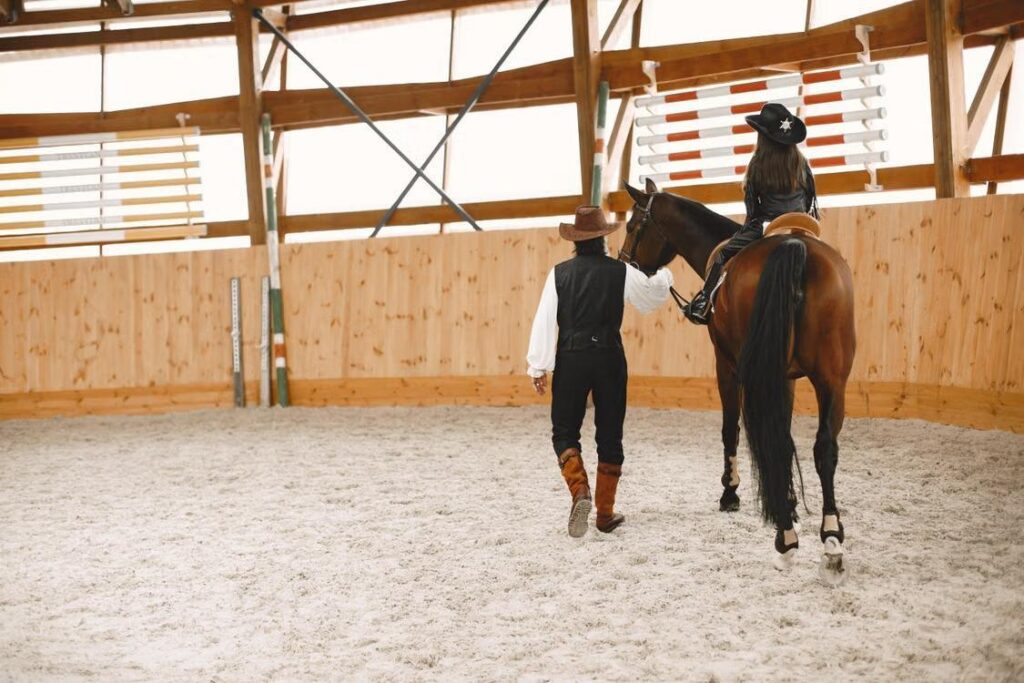 Handler with a horse in an indoor riding arena
